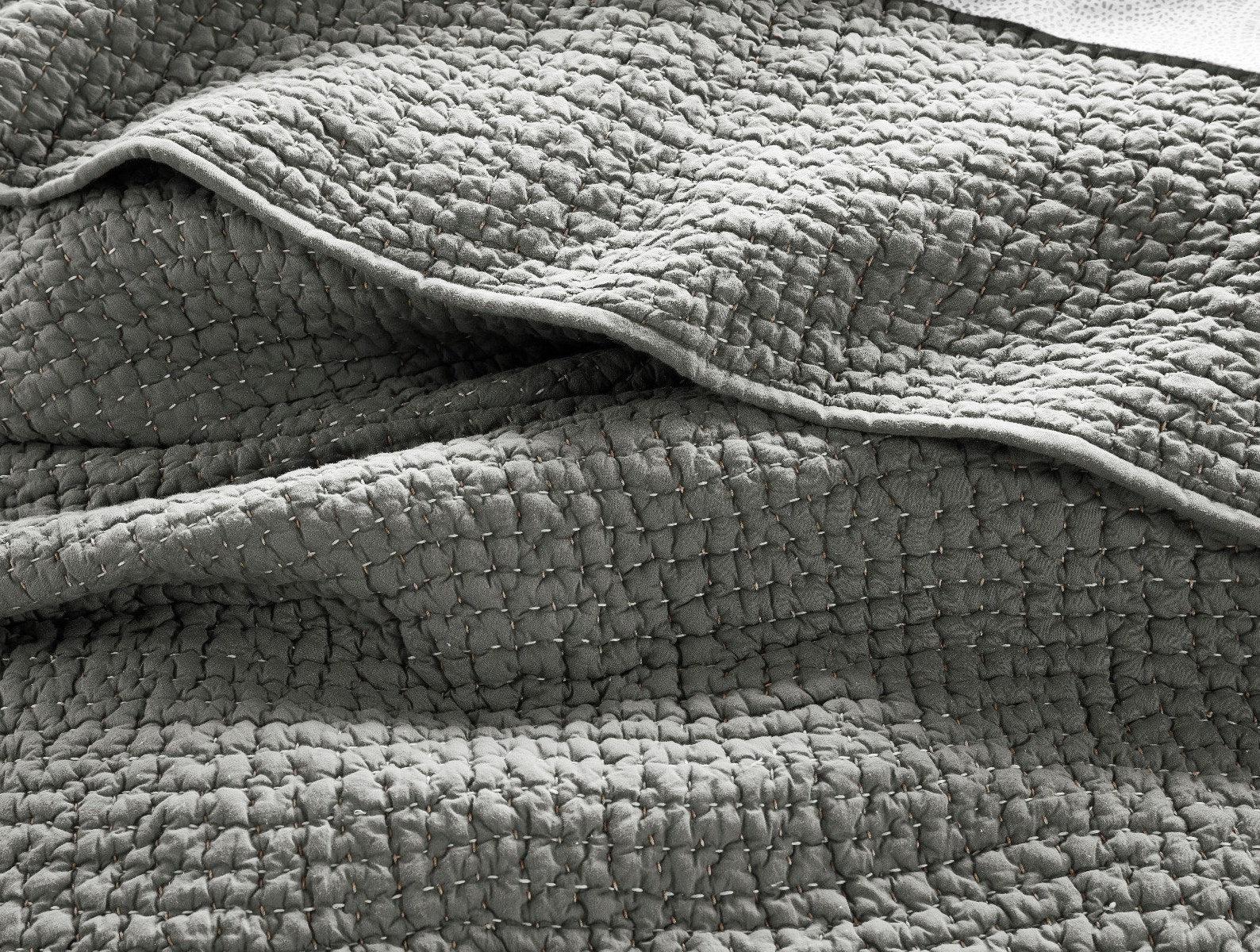 A close-up of the Pebbled Org Sham Euro Slate by Coyuchi Inc shows its textured gray organic cotton, with visible stitching and a gently crumpled look, highlighting the layered fabric and soft, cozy feel.