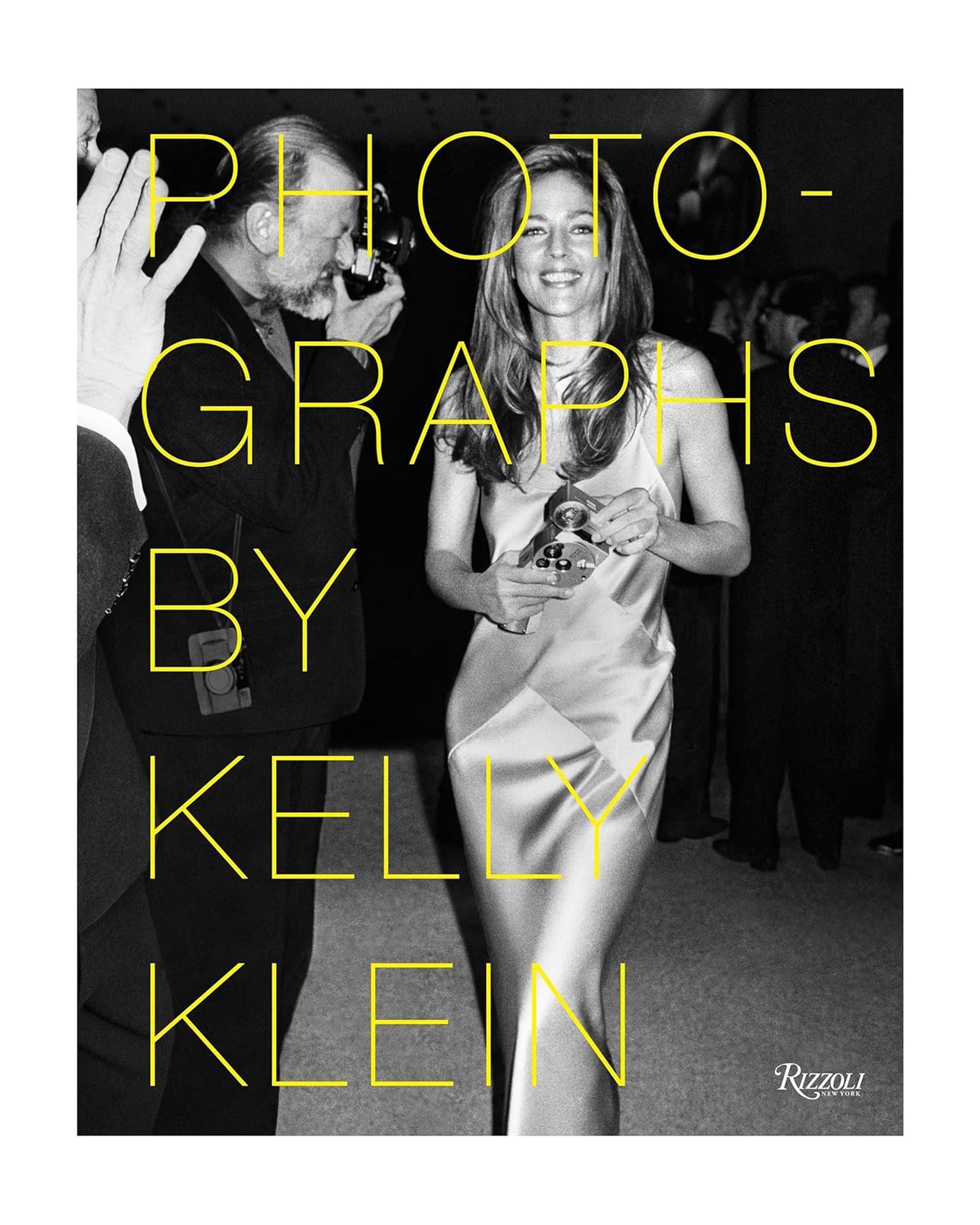 A woman in a silky dress holds an award and smiles at an event. Large yellow text reads "Photographs by Kelly Klein," showcasing classic American style. The Random House logo appears in the bottom right corner.