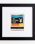 A framed vintage Match South matchbook cover, featuring the iconic Playboy bunny logo and horizontal stripes in blue, black, and orange, mounted on a white background within an Art Square Black Frame.