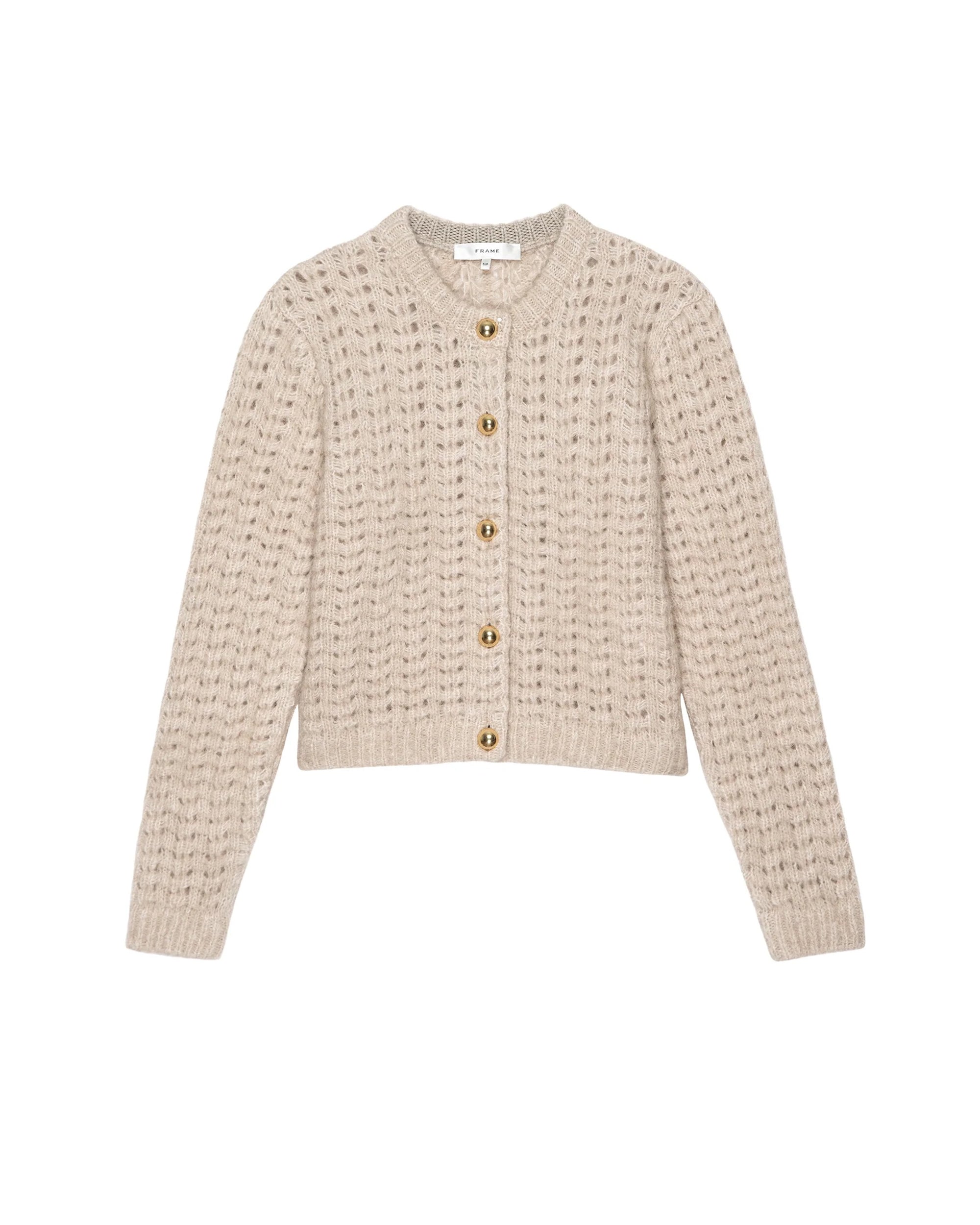 The Plush Cardi by FRAME is a beige, slightly cropped cardigan in soft alpaca merino wool with a textured knit, long sleeves, gold-toned buttons, and a round neckline.