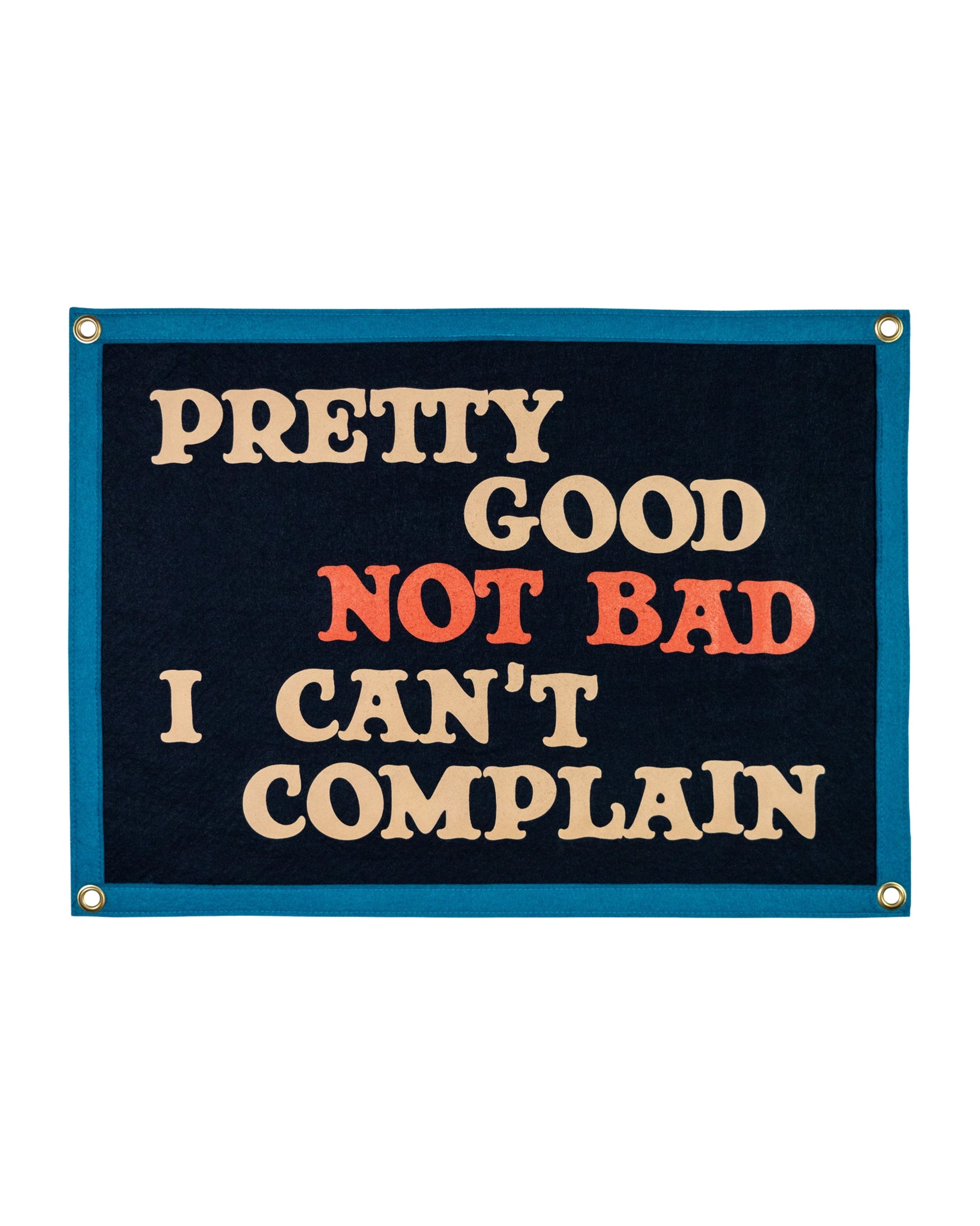 The Oxford Pennant "Pretty Good Not Bad I Can't Complain" banner is dark blue felt with cream and orange text, inspired by John Prine’s “That’s the Way the World Goes Round,” shown on a white background.