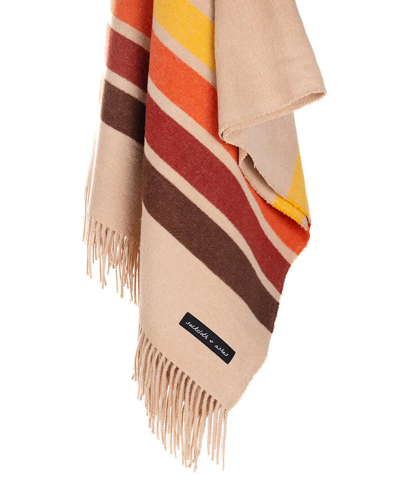 The Sackcloth & Ashes Desert Camp scarf by Sackcloth & Ashes is a cozy beige accessory with brown, orange, red, and yellow horizontal stripes, fringed ends, and a small black label near the fringe.