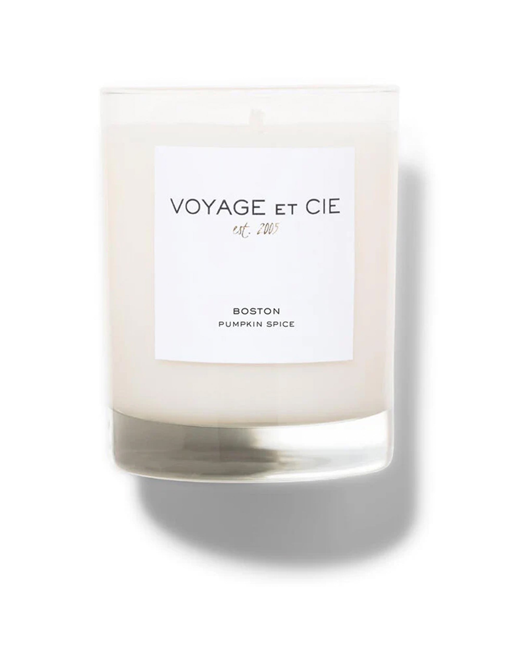 The 30 OZ/3 Wick Candle by Voyage Et Cie features a white pumpkin scent, presented in a clear glass jar with a white "VOYAGE ET CIE est. 2005, BOSTON, PUMPKIN SPICE" label—an organic, sustainable candle against a white background.
