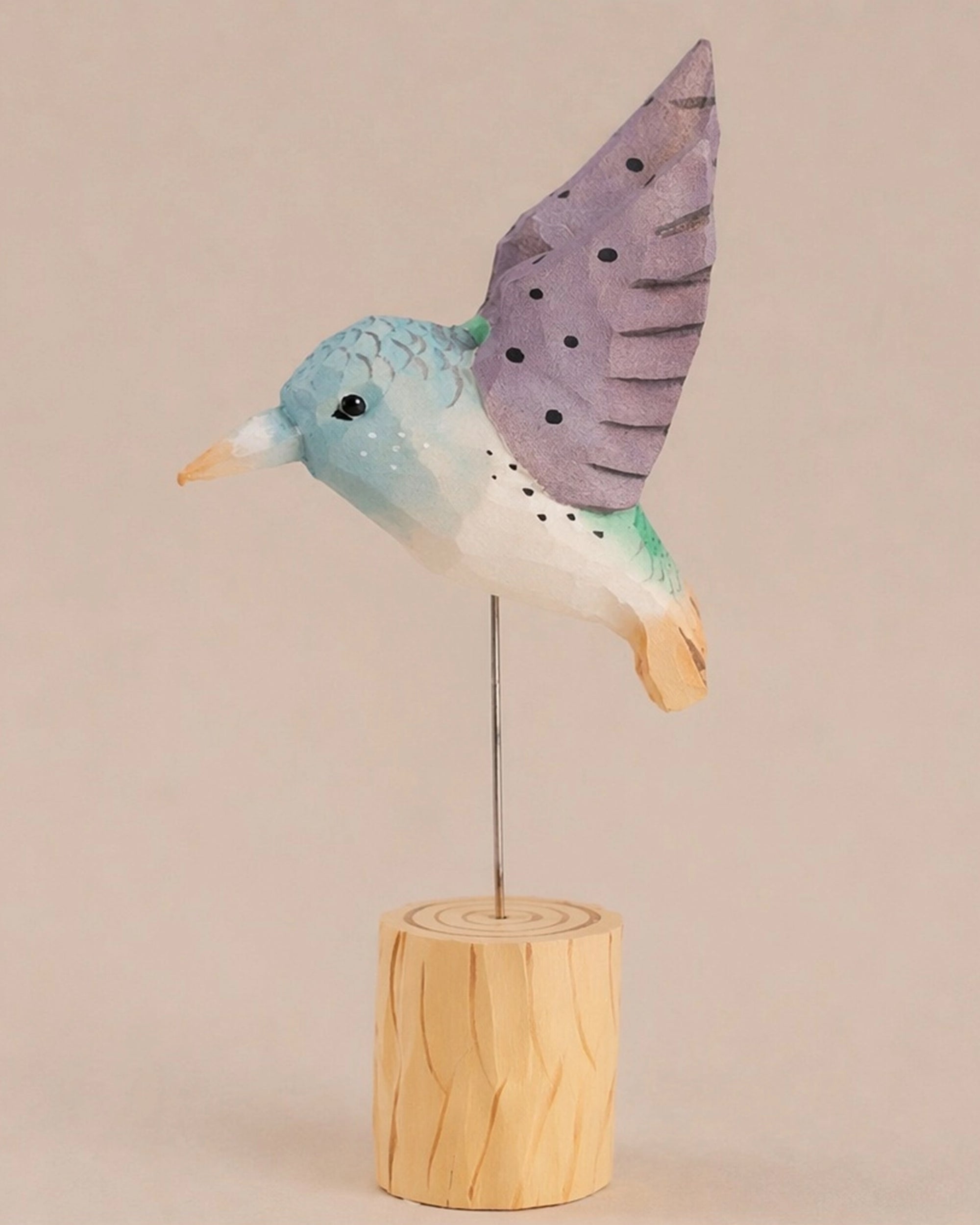 Purple hand-painted carved hummingbird on wire wings and wood base by Faire, decorative accent.
