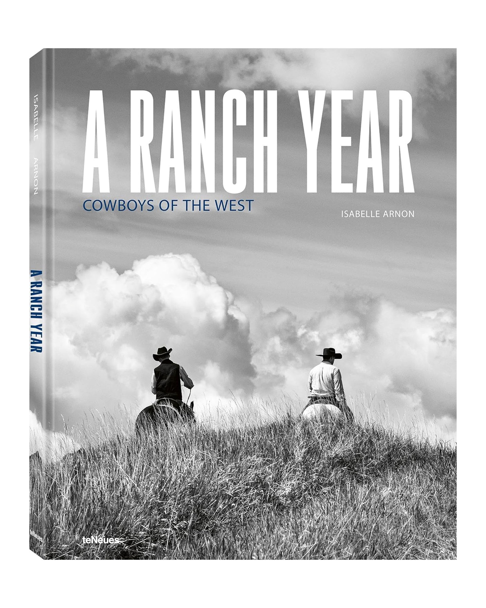 The black and white cover of "A Ranch Year" by Ingram Book Company depicts two cowboys on horseback atop a grassy hill beneath a cloudy sky, reflecting classic cowboy art.