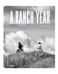 The black and white cover of "A Ranch Year" by Ingram Book Company depicts two cowboys on horseback atop a grassy hill beneath a cloudy sky, reflecting classic cowboy art.