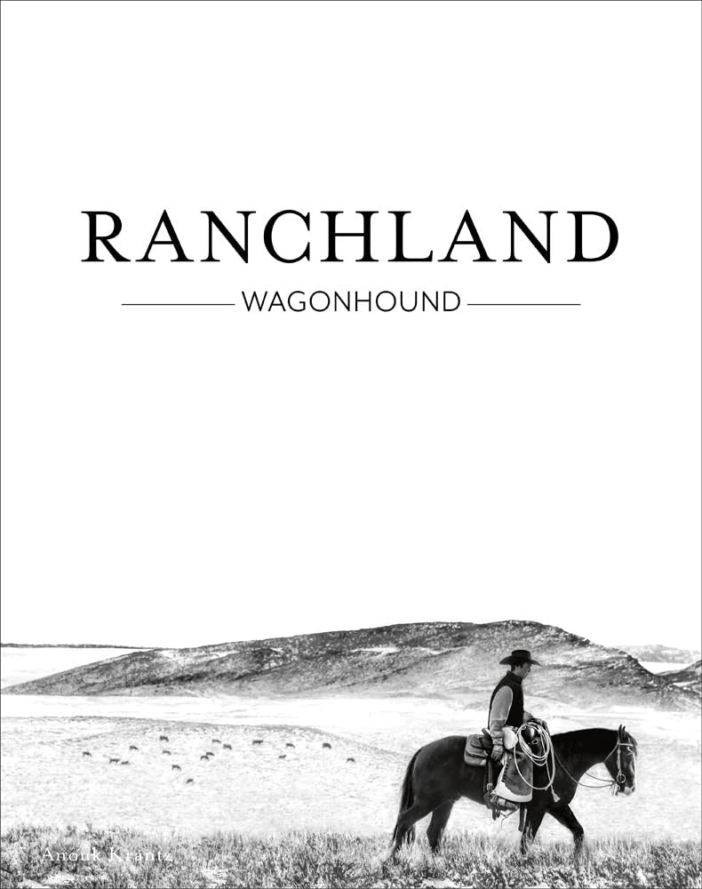 Black and white image of a cowboy on horseback overlooking a vast, hilly Arizona ranch landscape with grazing cattle, titled "Ranchland: Wagonhound" by National Book Network.