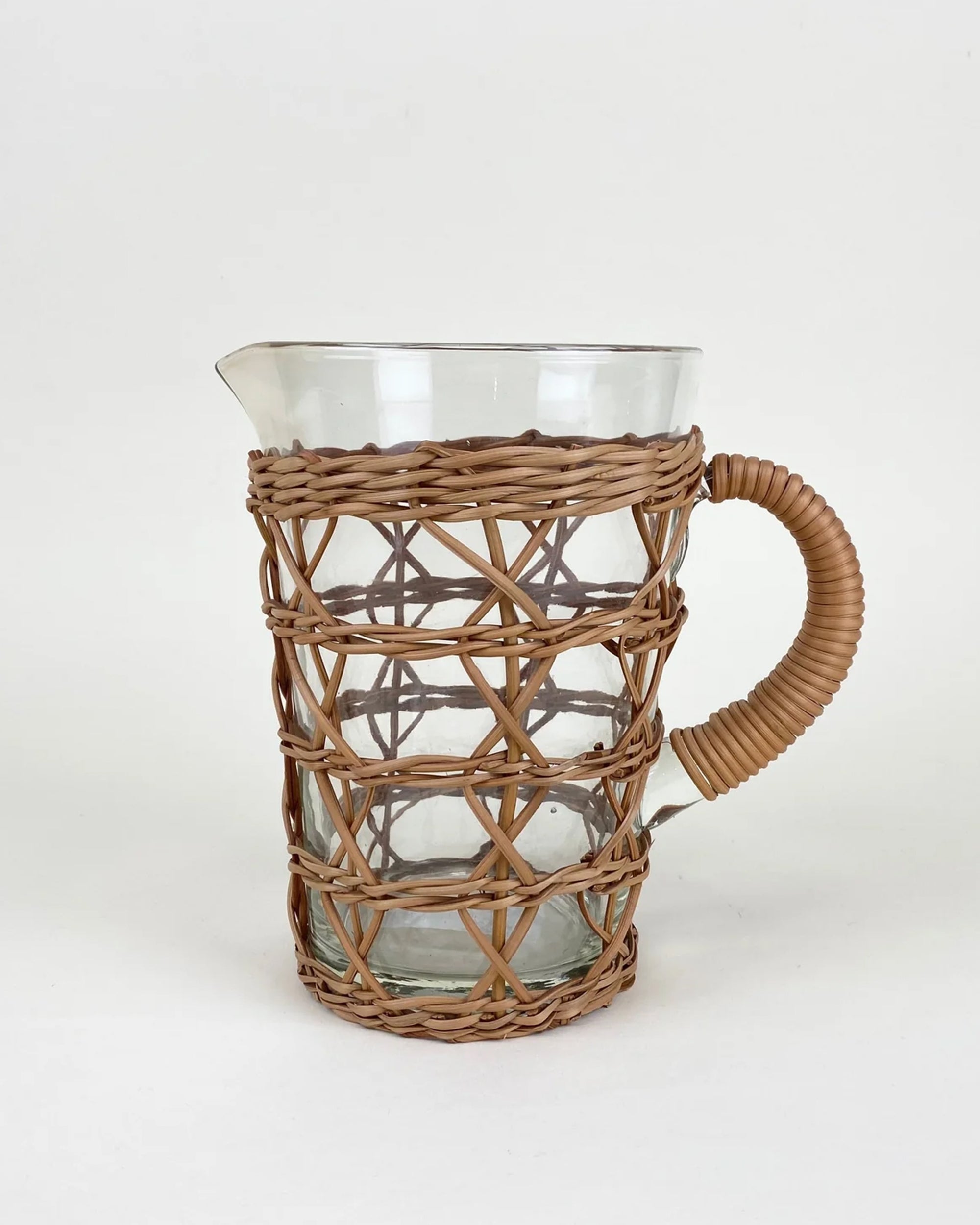 The Be Home 6880-CQ1374G Rattan Cage Pitcher is a clear glass pitcher featuring a woven rattan cover and wrapped handle, perfect for outdoor dining, displayed against a plain white background.