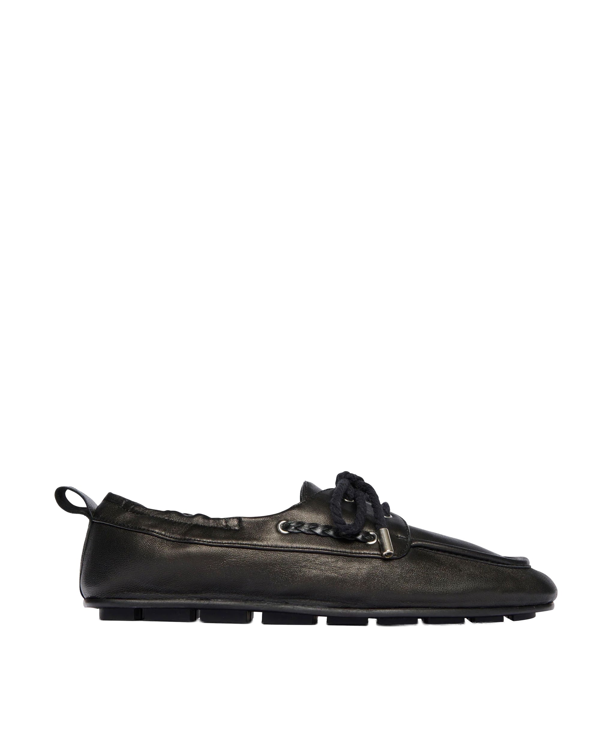 The Freda Salvador RIA Driver Loafer, shown in profile against a white background, is a black Nappa leather moccasin-style shoe with a flat rubber sole, decorative upper lacing, and a small heel pull tab.