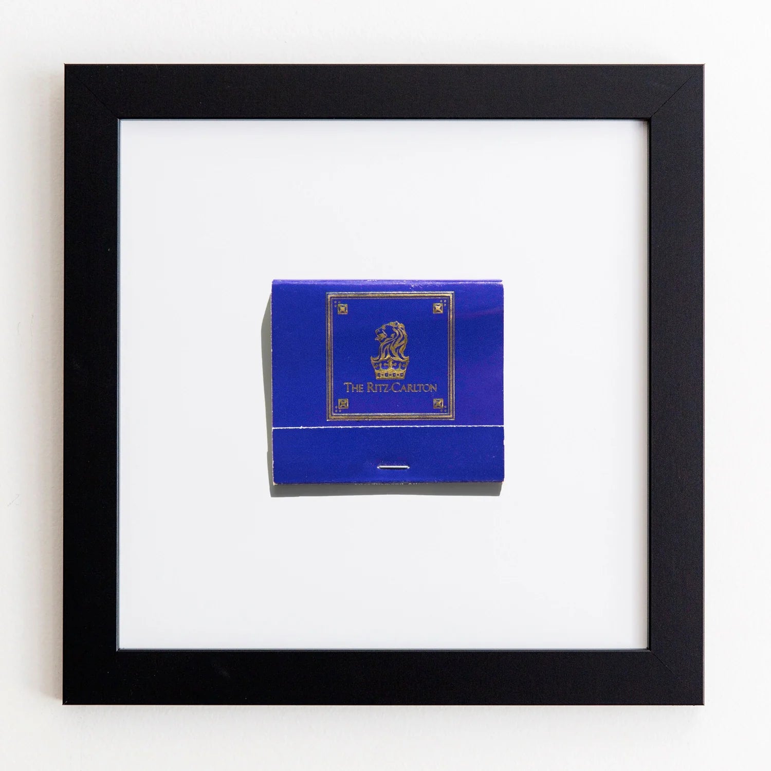 A framed Match South matchbook with a blue cover, centered within an Art Square black frame against a white background.