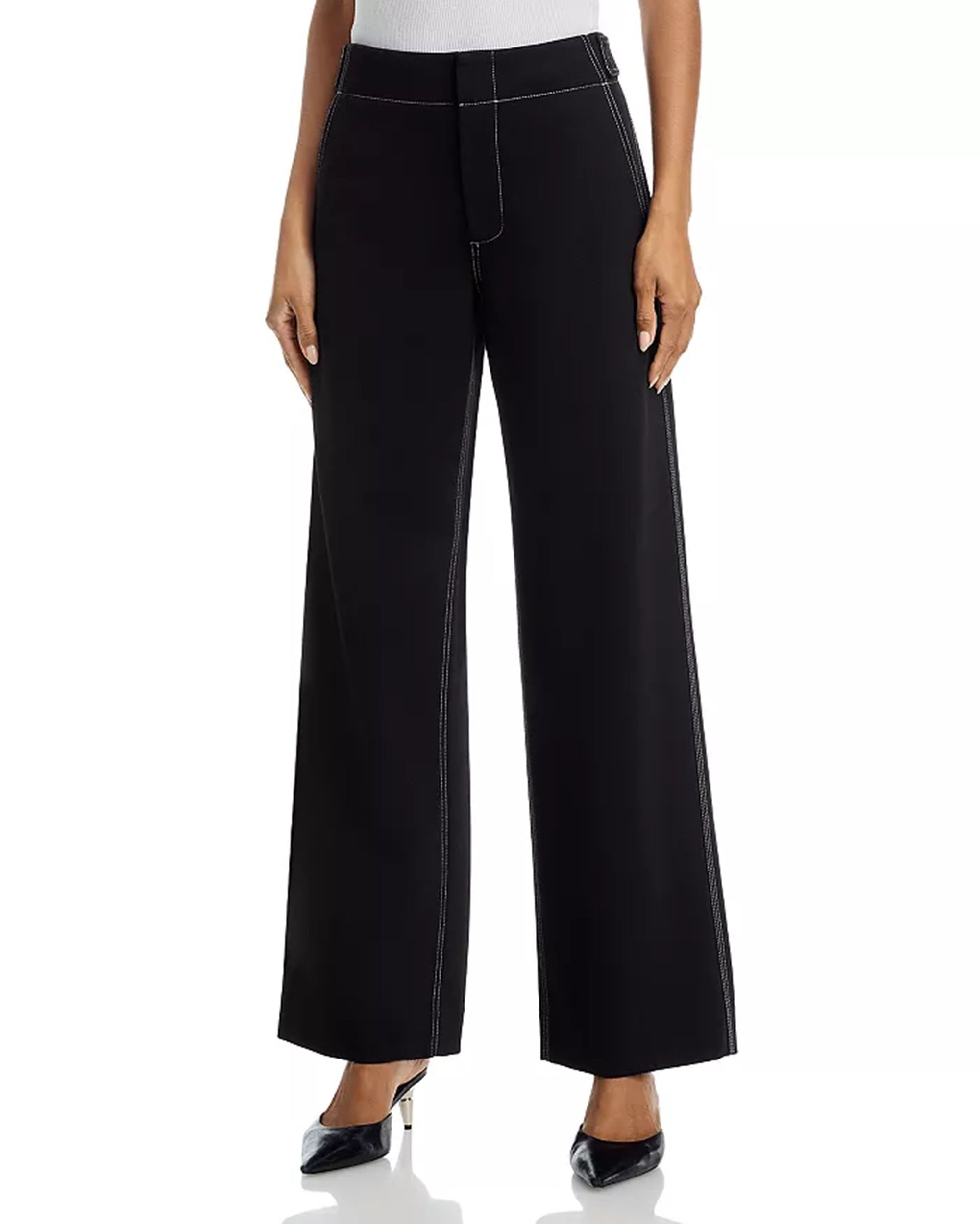A person wears Rag & Bone's Irina Pont Contrast Stitch Pants—high-waisted, relaxed fit wide-legs with white contrast stitching—paired with a white top and black pointed-toe shoes. The image shows the pants from waist to feet.