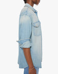 Oversized light blue denim shirt by Mother, sleeves rolled up, shown in side profile view.