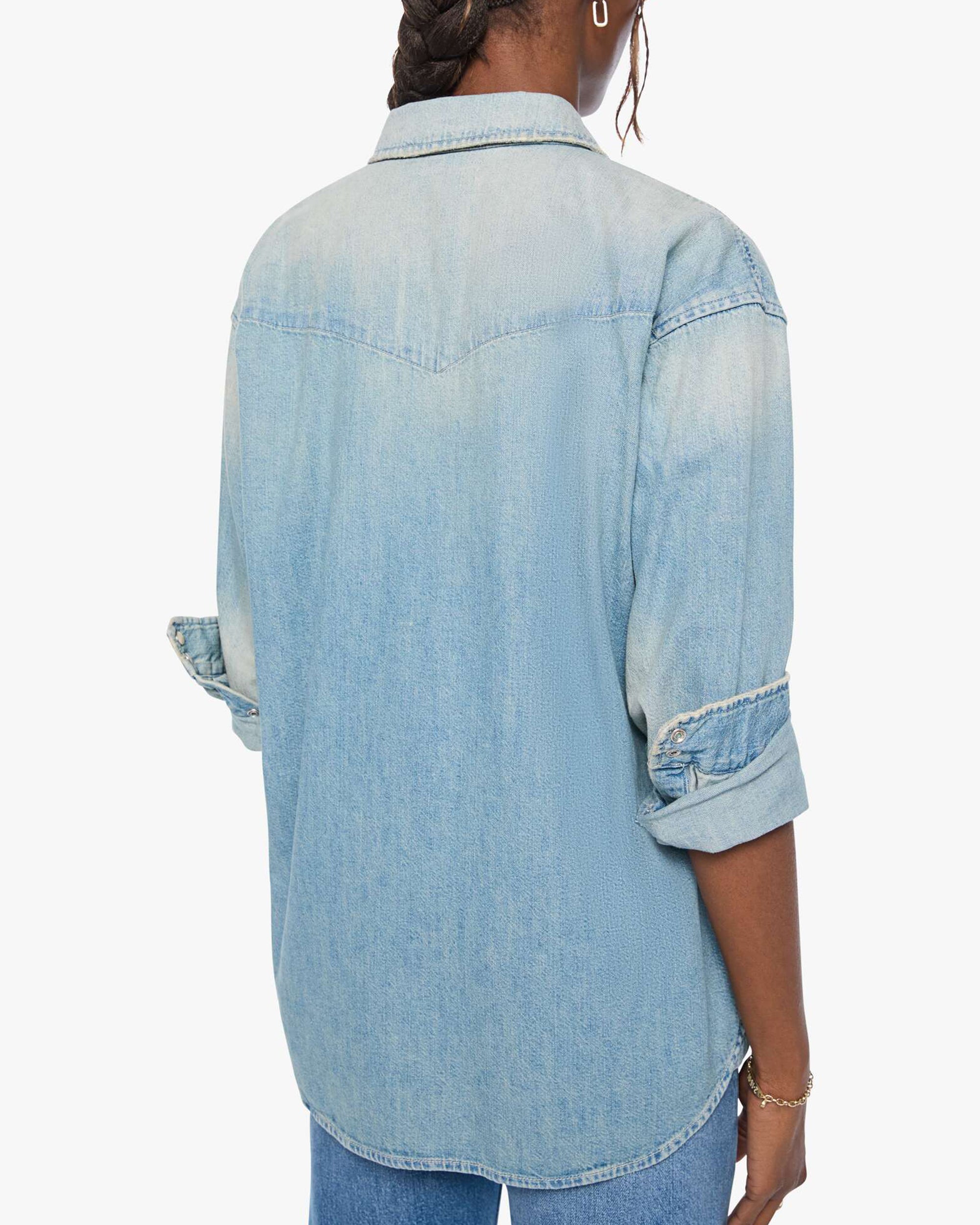 Oversized light blue denim button-up shirt and jeans by Mother, relaxed fit with rolled sleeves, casual style.