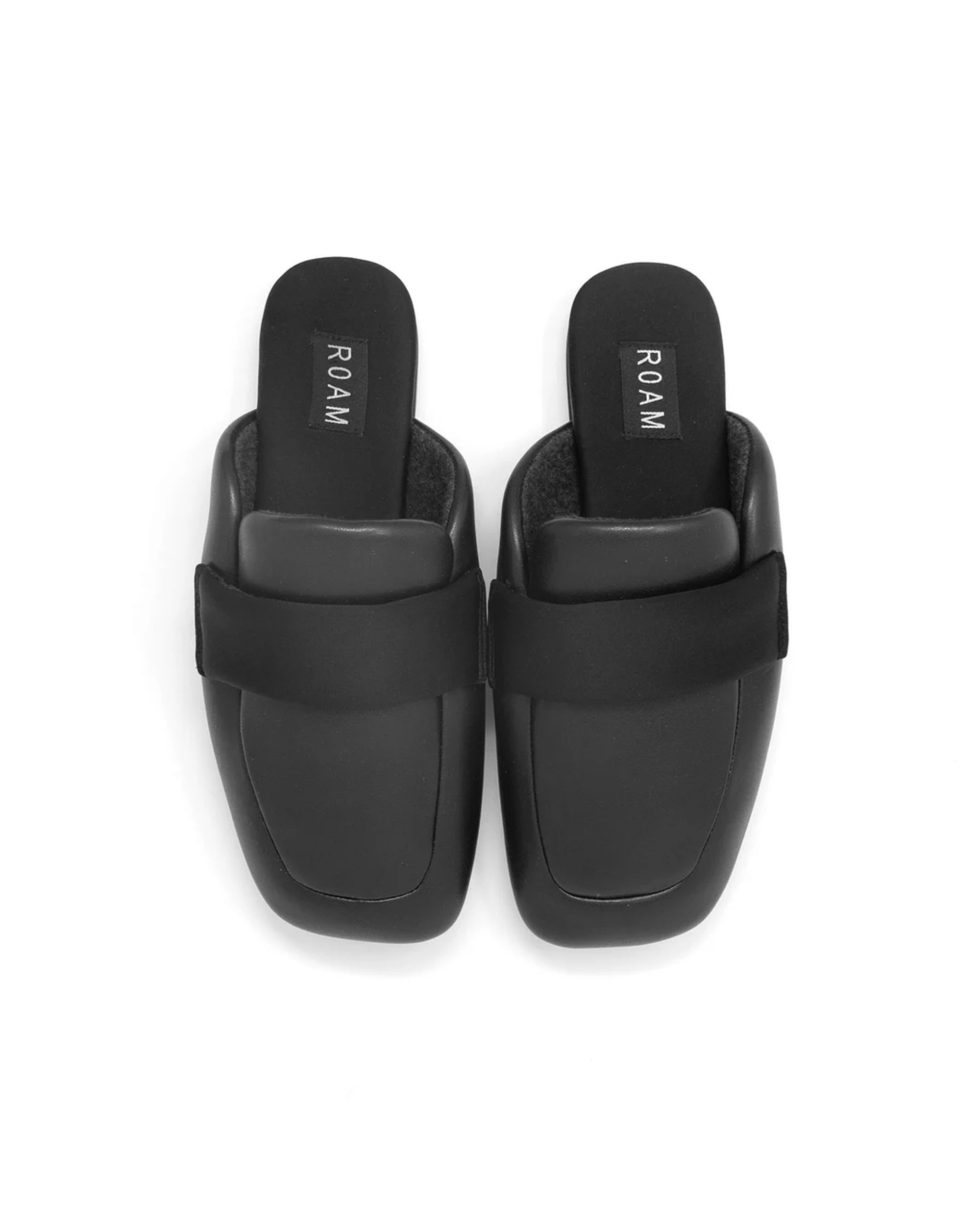 A pair of black Puffy Loafer slip-on mule loafers by Roam, with square toes, a wide top band, and memory foam insoles featuring the brand name, shown on a white background.