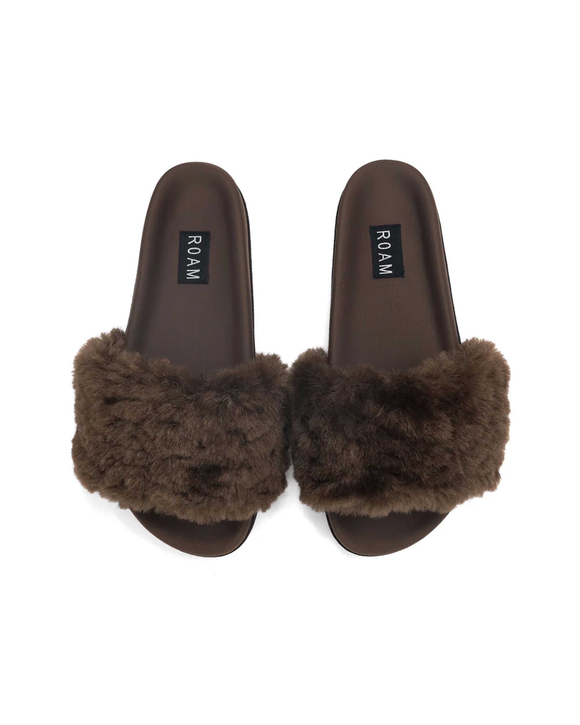 The Roam Cloud Shearling Slider sandals feature plush brown furry straps, black insoles with the Roam label, and a contoured footbed for comfort.