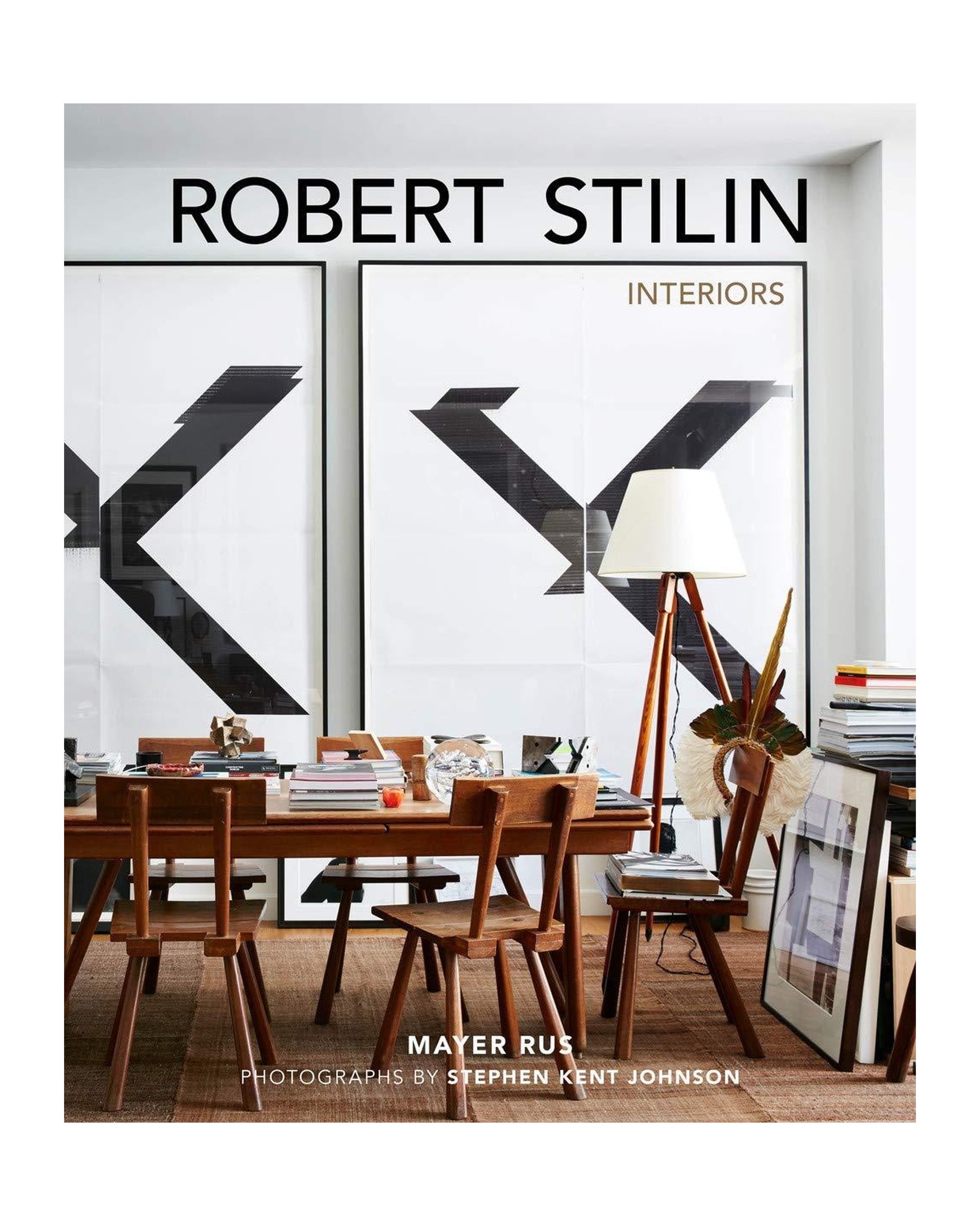 Book cover for "Robert Stilin Interiors" by Hachette Book Group, featuring a modern dining room with wooden chairs, curated decor, abstract wall art, and books—highlighting the designer's signature tailored style.