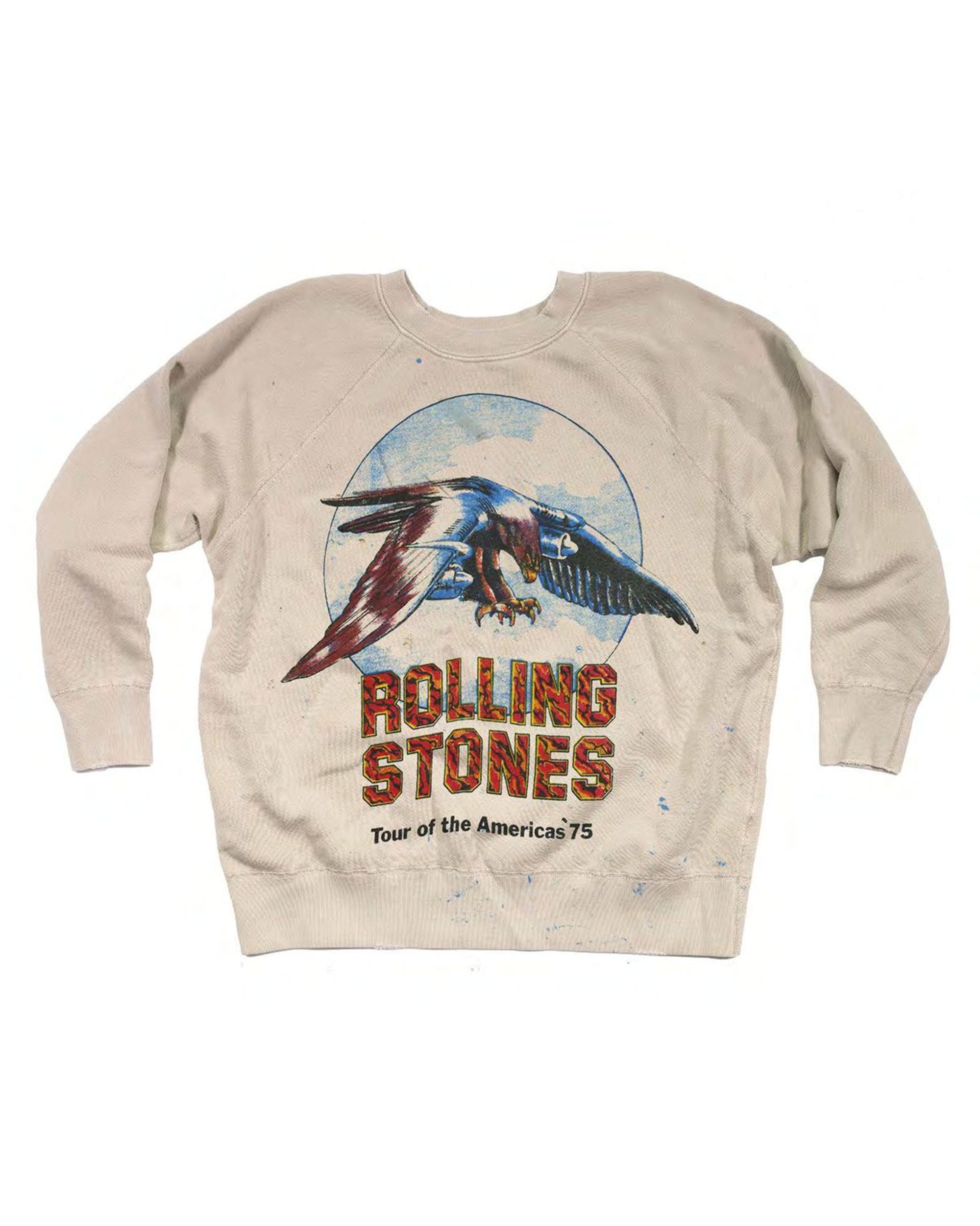 The Made Worn Rolling Stones LS is a beige shrunken sweatshirt with an eagle graphic in front of a blue circle and bold, textured “Rolling Stones” and “Tour of the Americas ‘75” text below.
