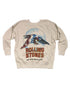 The Made Worn Rolling Stones LS is a beige shrunken sweatshirt with an eagle graphic in front of a blue circle and bold, textured “Rolling Stones” and “Tour of the Americas ‘75” text below.