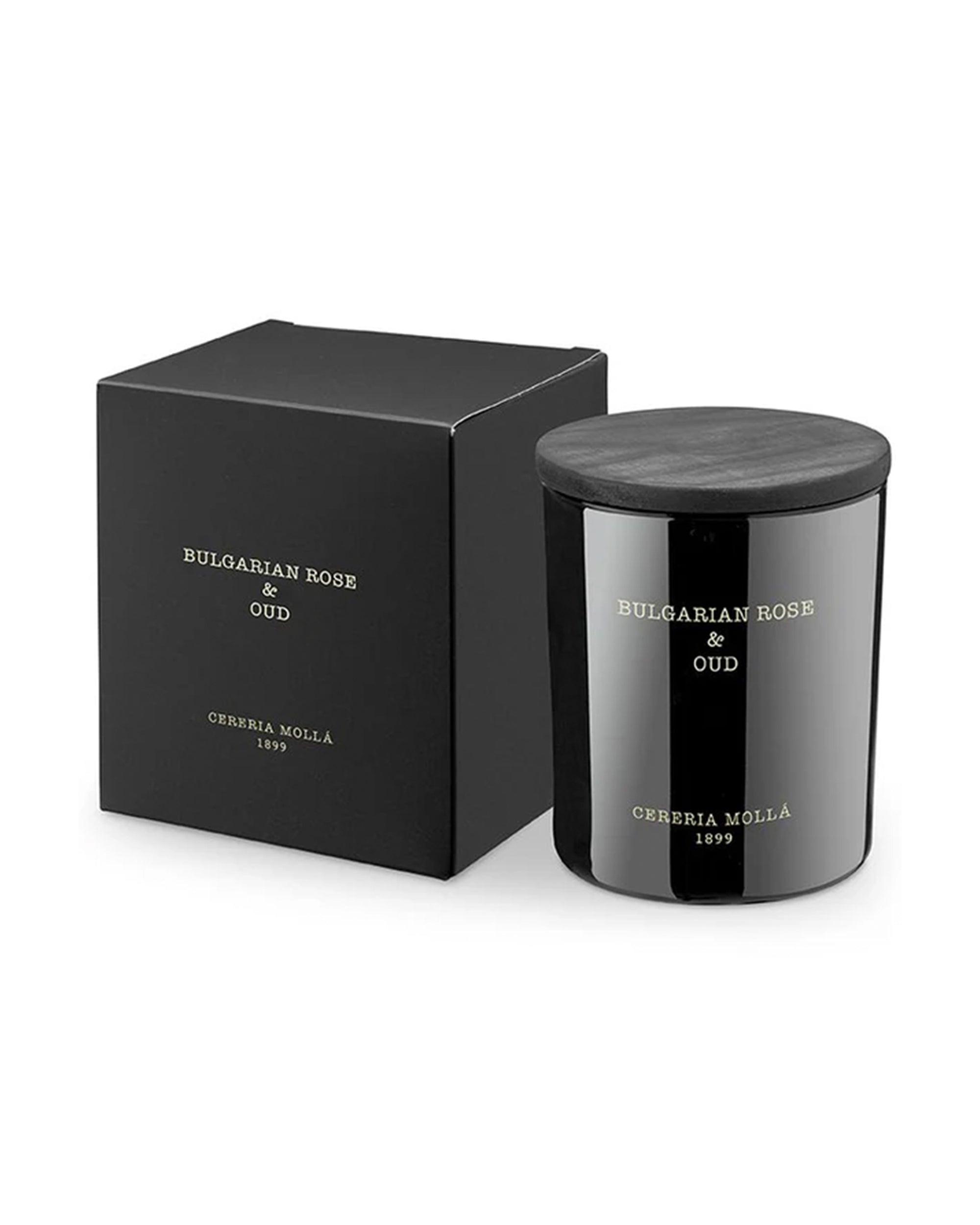 A black Bulgarian Rose & Oud Premium Candle (8 OZ) by European Scents LLC sits next to its matching black box, both featuring gold text on a white label.