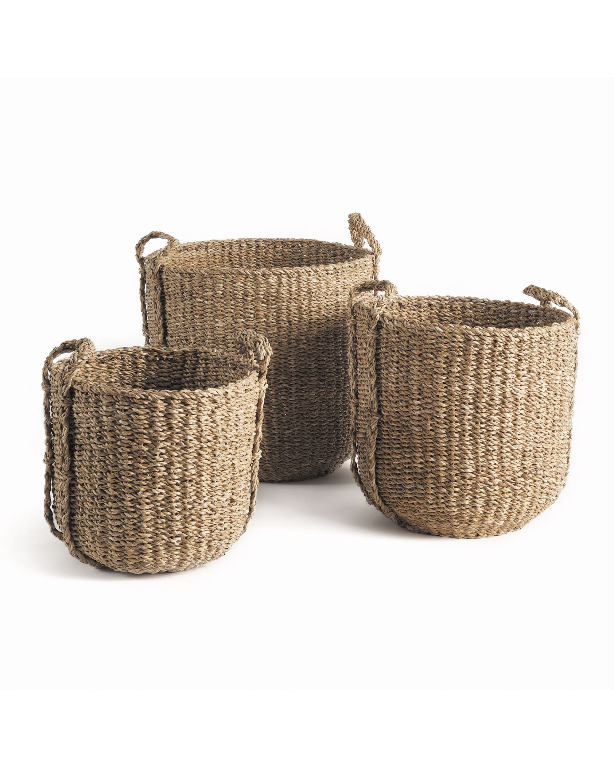 The NSG408 Seagrass Round Drum Baskets by Napa Home & Garden come in small, medium, and large sizes with handles. Their woven design adds an organic touch to any space, making them ideal for storage and décor. Displayed on a white background.