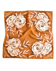 The Faire Rustic Wild Rose Western Silk Scarf features a brown background with white and light pink floral and leaf patterns symmetrically edged—a chic, sustainable cowgirl accessory.