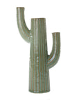 The Saguaro Vase by Accent Decor is a ceramic cactus-inspired vase featuring a tall central column, two upward-curving arms, and a light green reactive glaze with vertical brown lines.