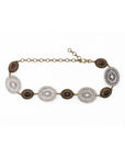 The Brass & Silver Concho belt by Streets Ahead Inc features alternating large silver and small brown oval medallions, linked by a bronze chain with an adjustable clasp—an eye-catching boho accessory for any outfit.