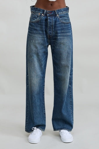Denimist ALLFIT loose-fit jeans in denim styled with white sneakers, shown against a light background.