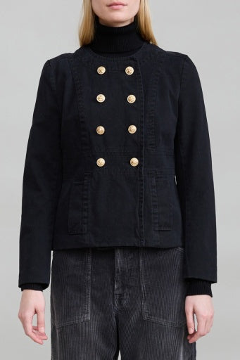 Denimist Shrunken Officer Jacket with gold buttons, styled over a black turtleneck and gray corduroy pants.