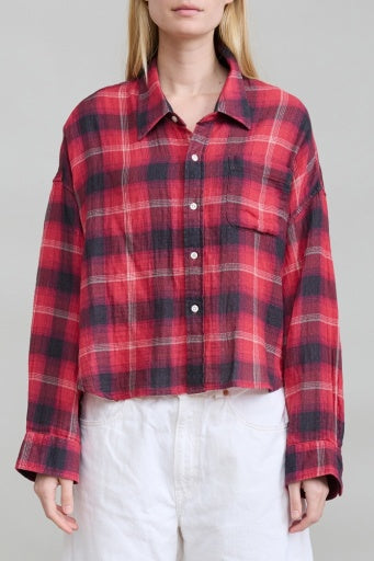 Red and black plaid cropped shirt by Denimist styled with white pants against a minimalist background.