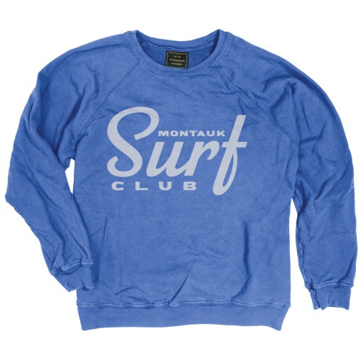 A blue crewneck sweatshirt with &quot;MONTAUK SURF CLUB&quot; printed in white, displayed against a plain background at a Scottsdale, Arizona bungalow by Wildcat Retro Brands.