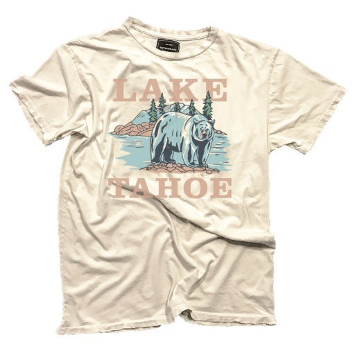 A LAKE TAHOE vintage white T-shirt from Wildcat Retro Brands showcases a charming illustration of a bear by water with mountains behind. The words "Lake Tahoe" are stylishly printed above and below the image. This unisex tee is crafted with pride in the USA, combining style and quality.