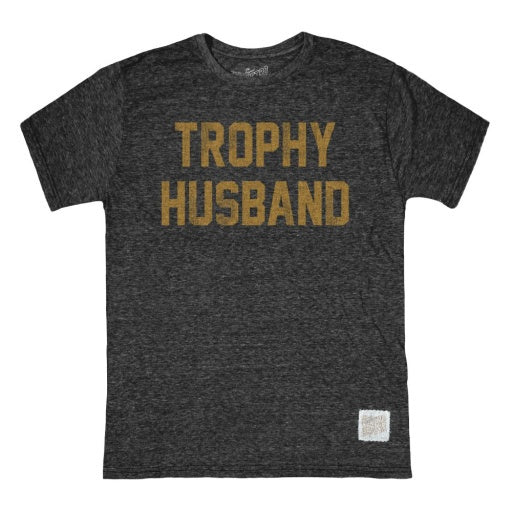 The TROPHY HUSBAND tee by Wildcat Retro Brands is a unisex, dark gray triblend shirt featuring bold yellow lettering across the front.