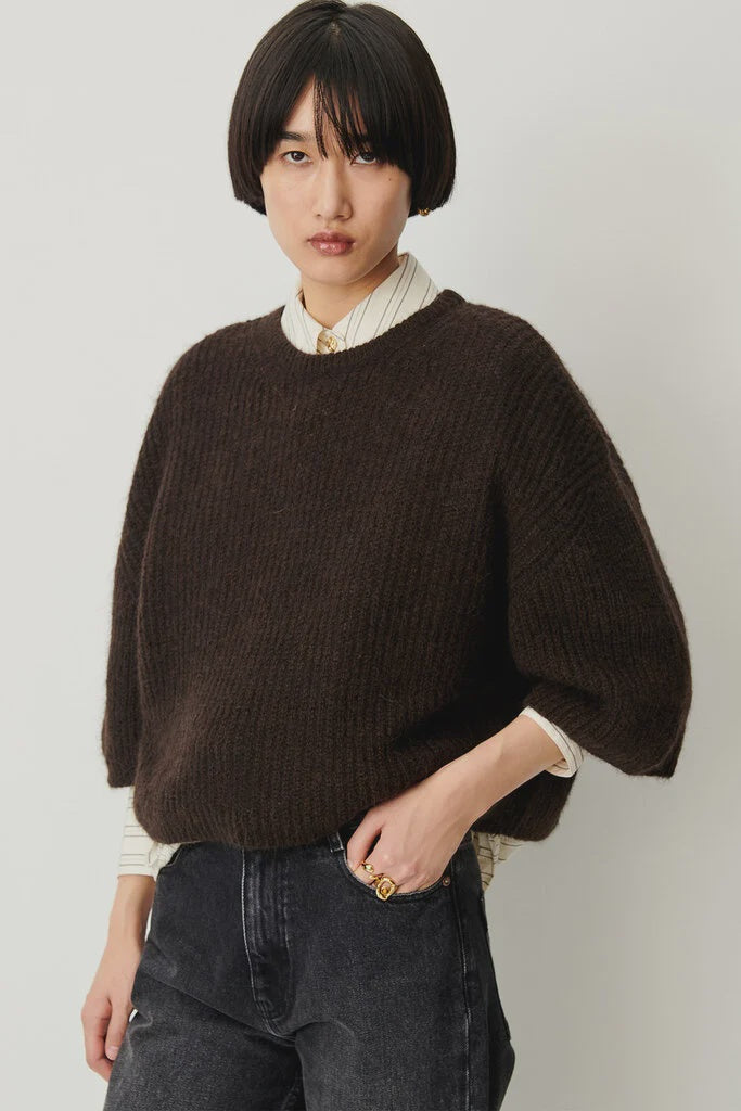 Sessun Tallon Long Sleeve Sweater and striped shirt styled with dark jeans, modern casual look on plain background.