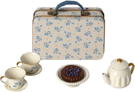 A floral Maileg Furniture suitcase with blue handle sits behind a cute toy tea set—perfect for Maileg mouse or dollhouse—including a white teapot, teacups, and a plate with chocolate cake topped with blueberries.