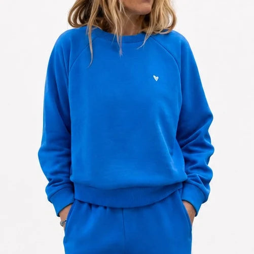 Kerri Rosenthal Super Soft Fleece Shrunken Sweatshirt and pants in white, relaxed fit with hands in pockets.