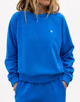 Kerri Rosenthal Super Soft Fleece Shrunken Sweatshirt and pants in white, relaxed fit with hands in pockets.