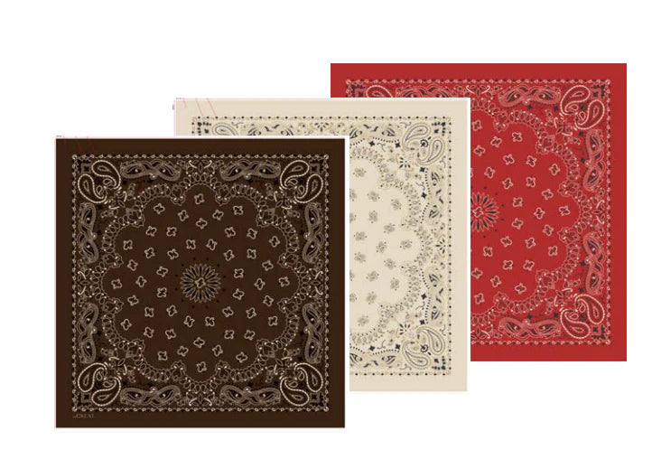 Three Silk Bandanas by The Great Inc. overlap—front brown, middle white, back red—each featuring intricate paisley and floral patterns along the border and center.