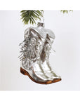 The Faire Cowgirl Boot Ornament features shiny silver with glitter details and brown soles, hanging from your Christmas tree to add a western flair to your holiday décor.