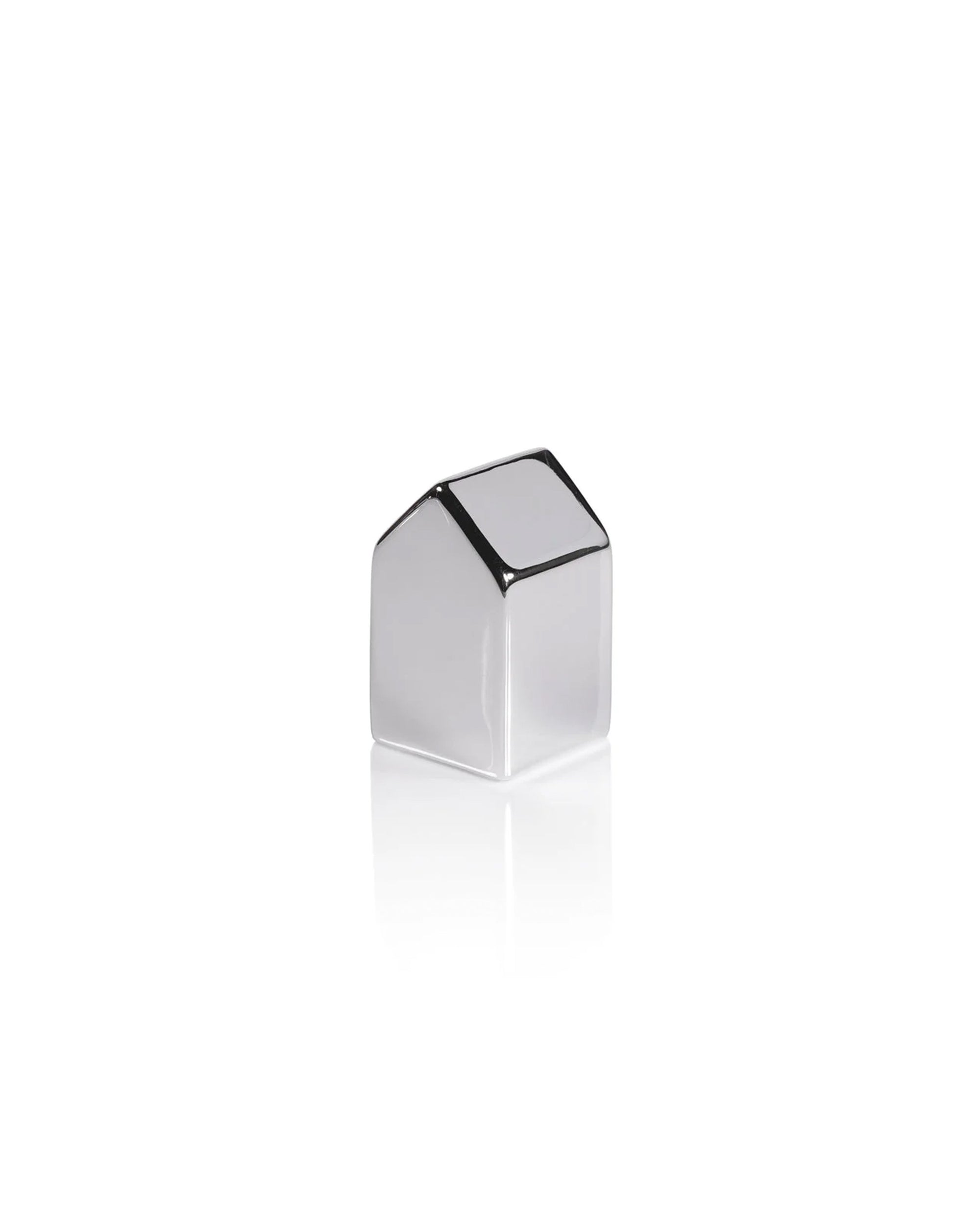 The Zodax Ceramic House Silver L is a small, minimalist ceramic decor piece with a slanted roof and sleek silver finish—ideal for modern holiday displays. Shown on a white background with a faint reflection.