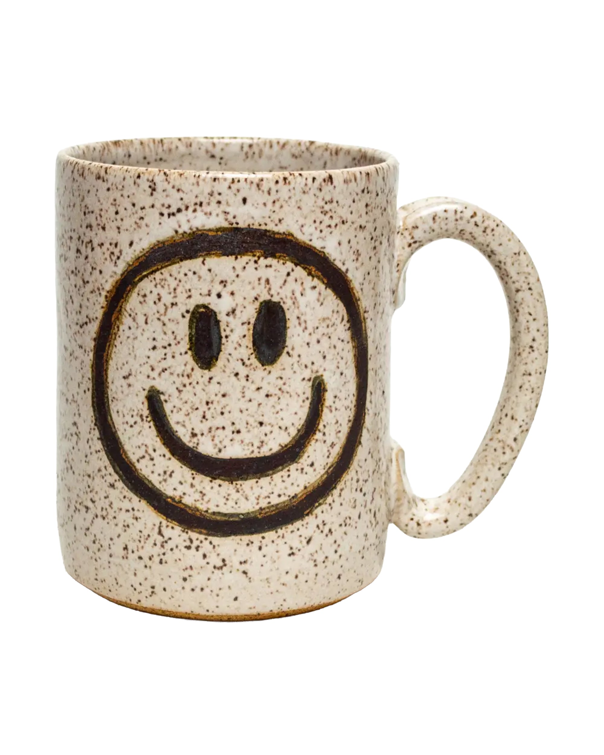 The Faire Ceramic Mug is a beige speckled handmade mug with a large handle and a black smiley face on the side. Dishwasher safe, it adds charm and practicality to any ivory mug collection.