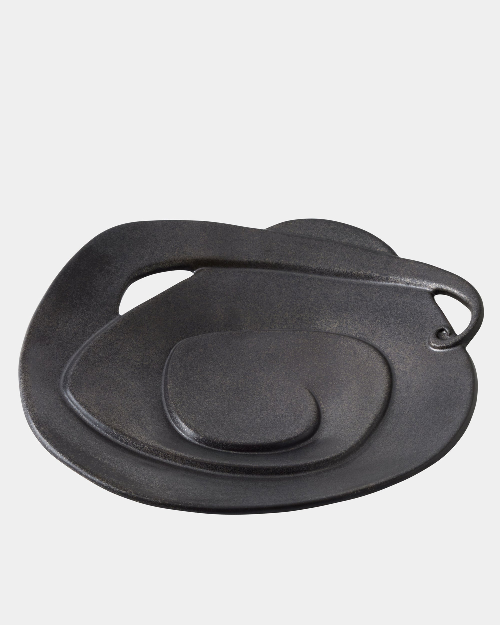 The Global Views Spiral Plate Black features a modern, layered design with a handle-like curve and rich black glaze, displayed against a plain white background.