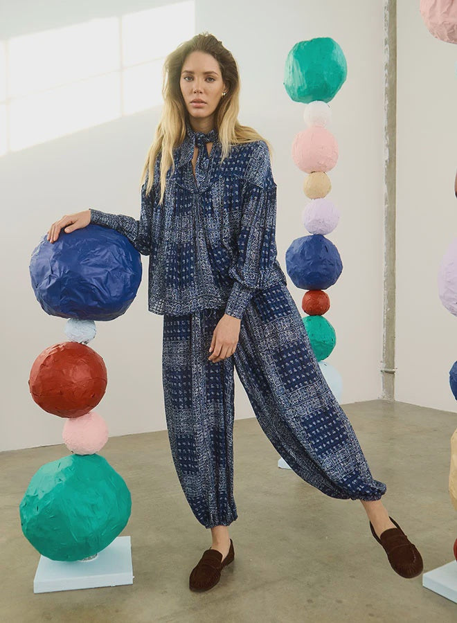 Hunter Bell NYC Briggs Pant in a colorful, artistic indoor setting with playful stacked paper ball sculptures.
