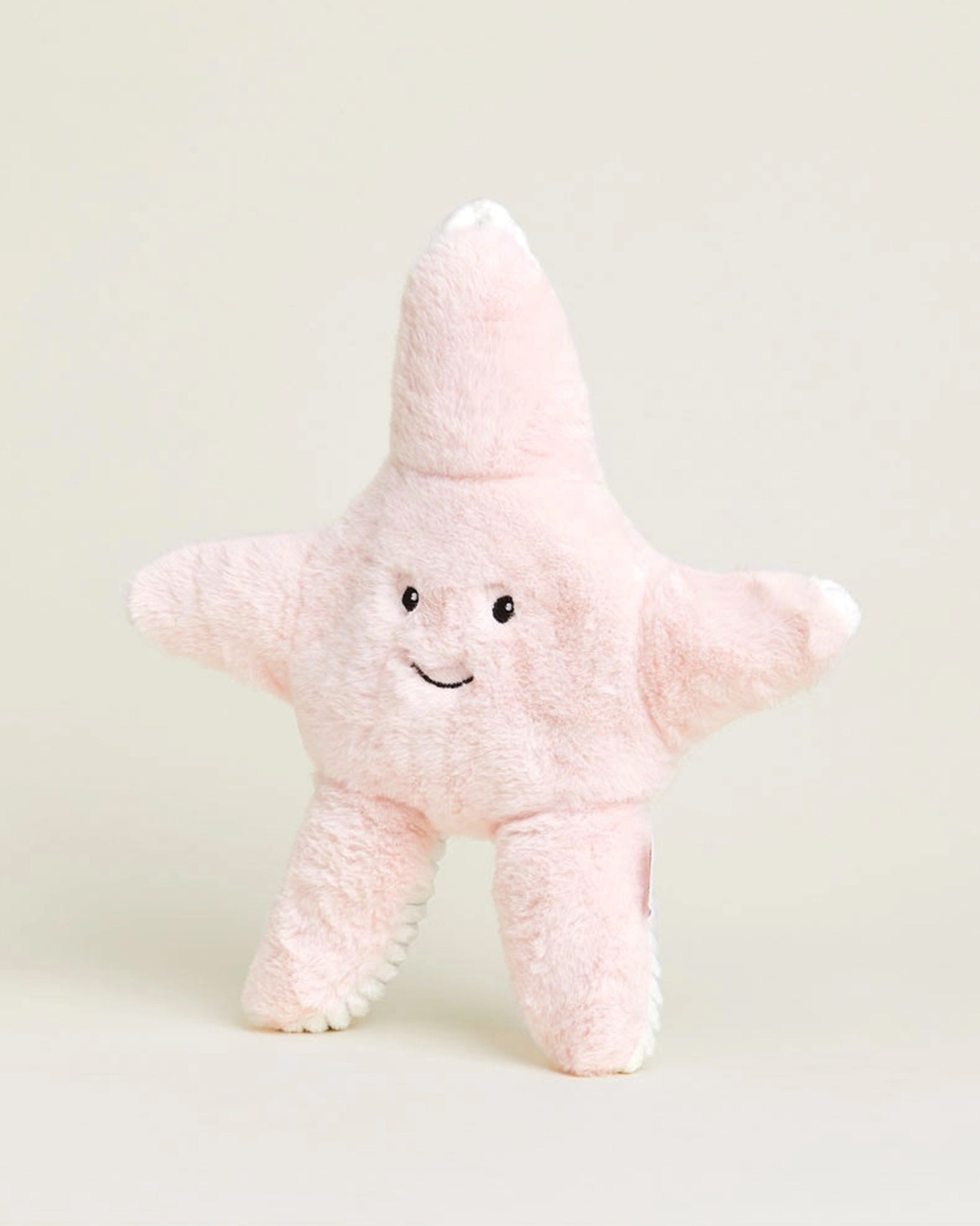 The Faire Starfish Warmies is a soft, plush pink starfish toy with a smiling face and black eyes that can be microwaved for soothing warmth and ultimate comfort.
