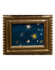 SKY & STARS by Tak Design: A hand-painted artwork in vintage frames, featuring a dark blue night sky with white, yellow, and red stars of varying sizes on a textured background—crafted by a local artist.