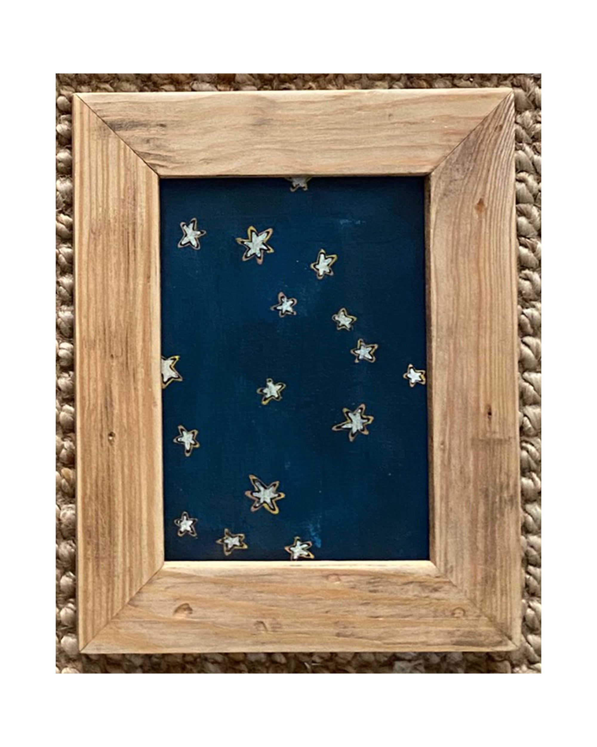 SKY &amp; STARS by Tak Design features hand-painted art: a dark blue background with yellow stars, framed in vintage wood and displayed on a woven textured surface.
