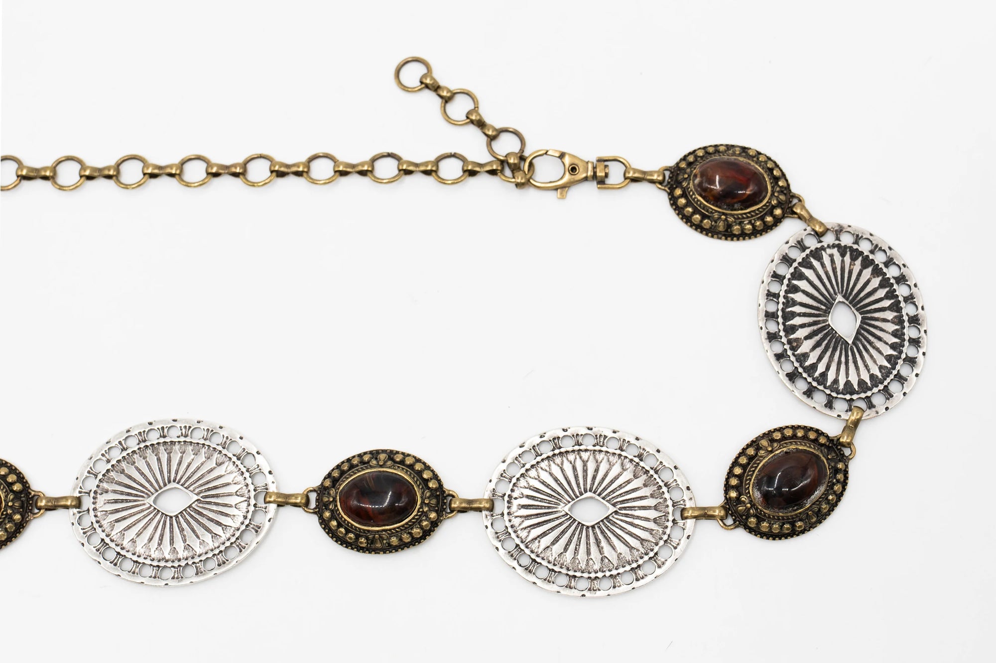 The Brass & Silver Concho by Streets Ahead Inc is a vintage-style necklace with alternating oval silver filigree and dark brown gemstones, joined by a mixed metal brass chain and clasp, shown on a white background.