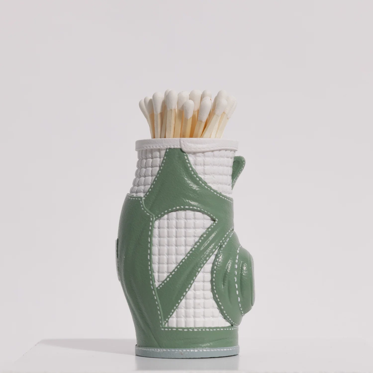 A Match South Matchstick Striker golf bag-shaped container holding several wooden matches, set against a plain white background. The bag is white with Arizona-style green accents.