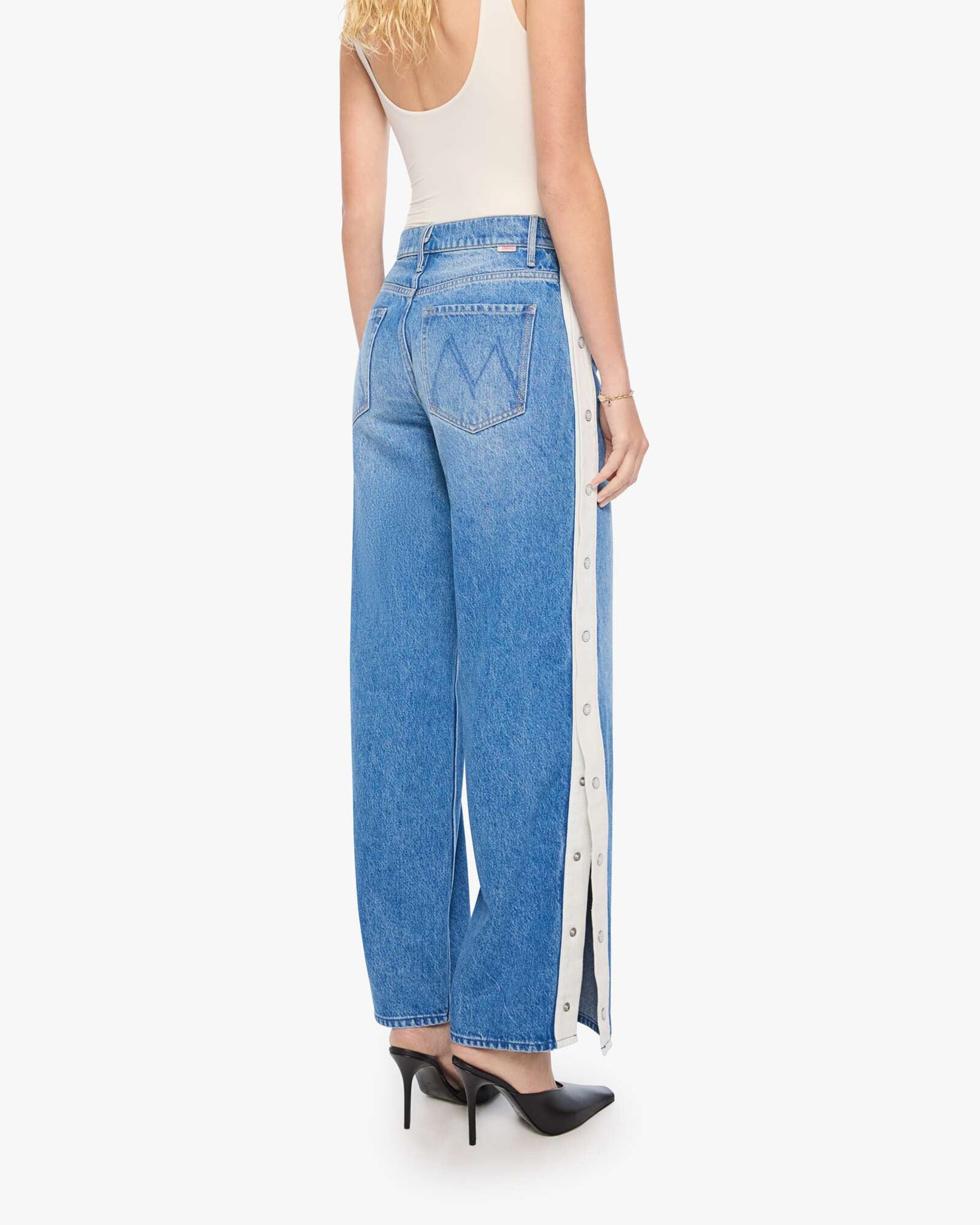 The Striped Resealable Skimp jeans by Mother, blue stripes, styled with a cream tank and black heels, back view.