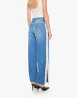 The Striped Resealable Skimp jeans by Mother, blue stripes, styled with a cream tank and black heels, back view.